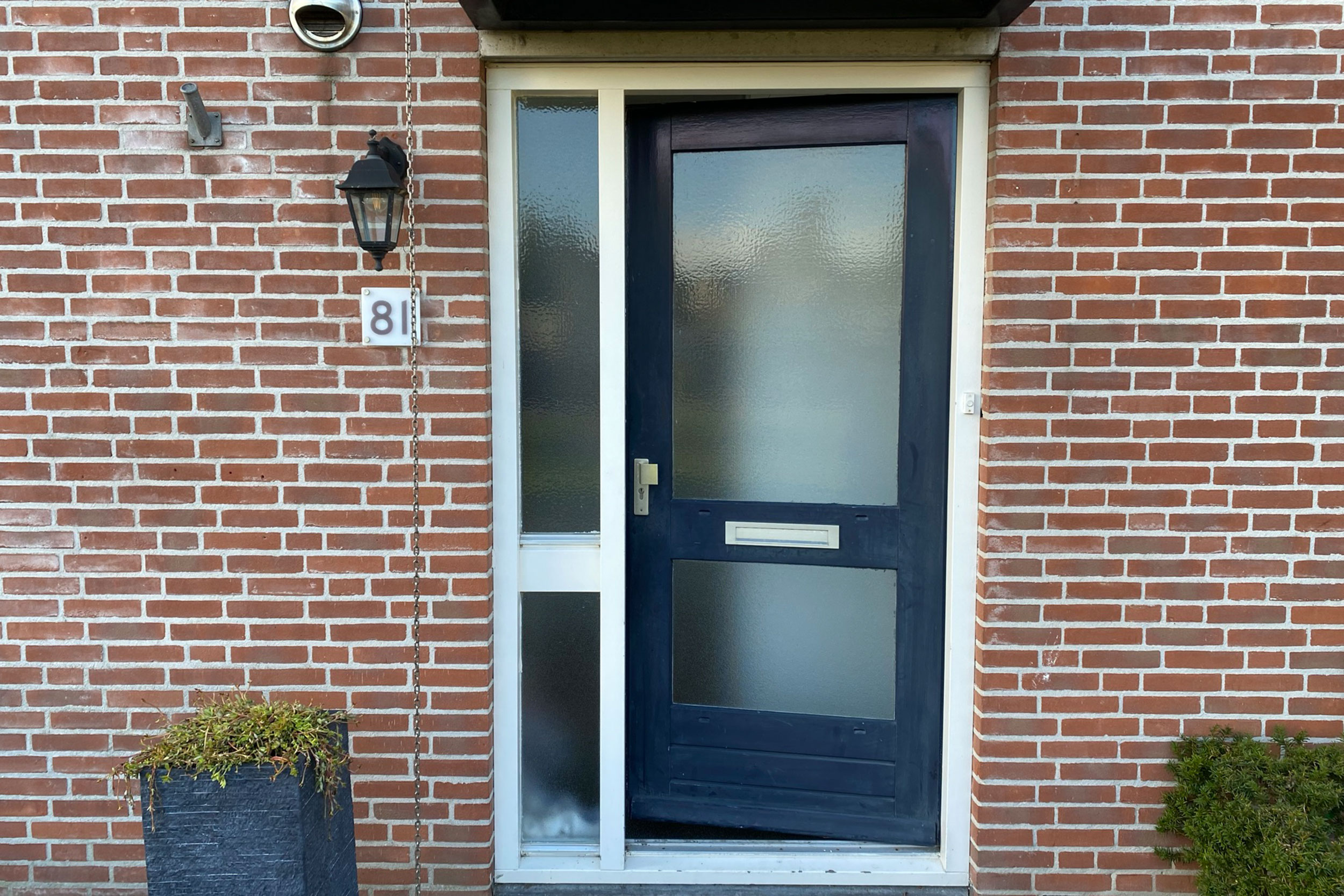 Moderne voordeur met glaspartijen, ideaal voor woningrenovatie project